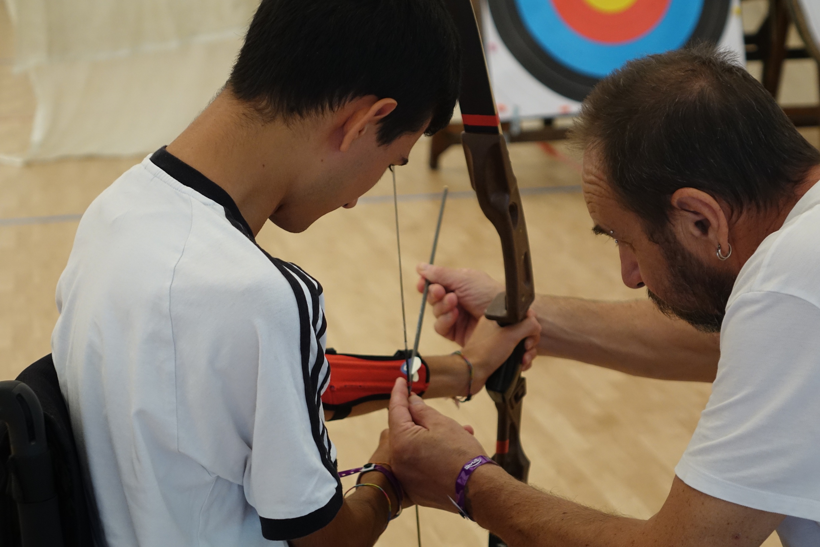 tecnico di tiro con l'arco che aiuta l'atleta