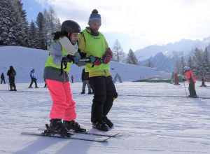 atleta non vedente che impara a sciare guidato dal maestro