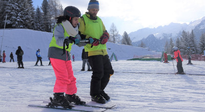 atleta non vedente che impara a sciare guidato dal maestro